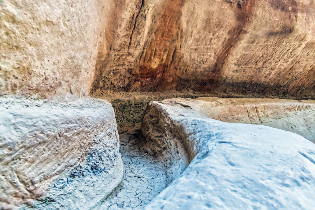 An ancient, eroded stone staircase carved into a rock face, showcasing the weathered steps and striations on the surrounding rock surface, indicative of historical architecture or old ruins.